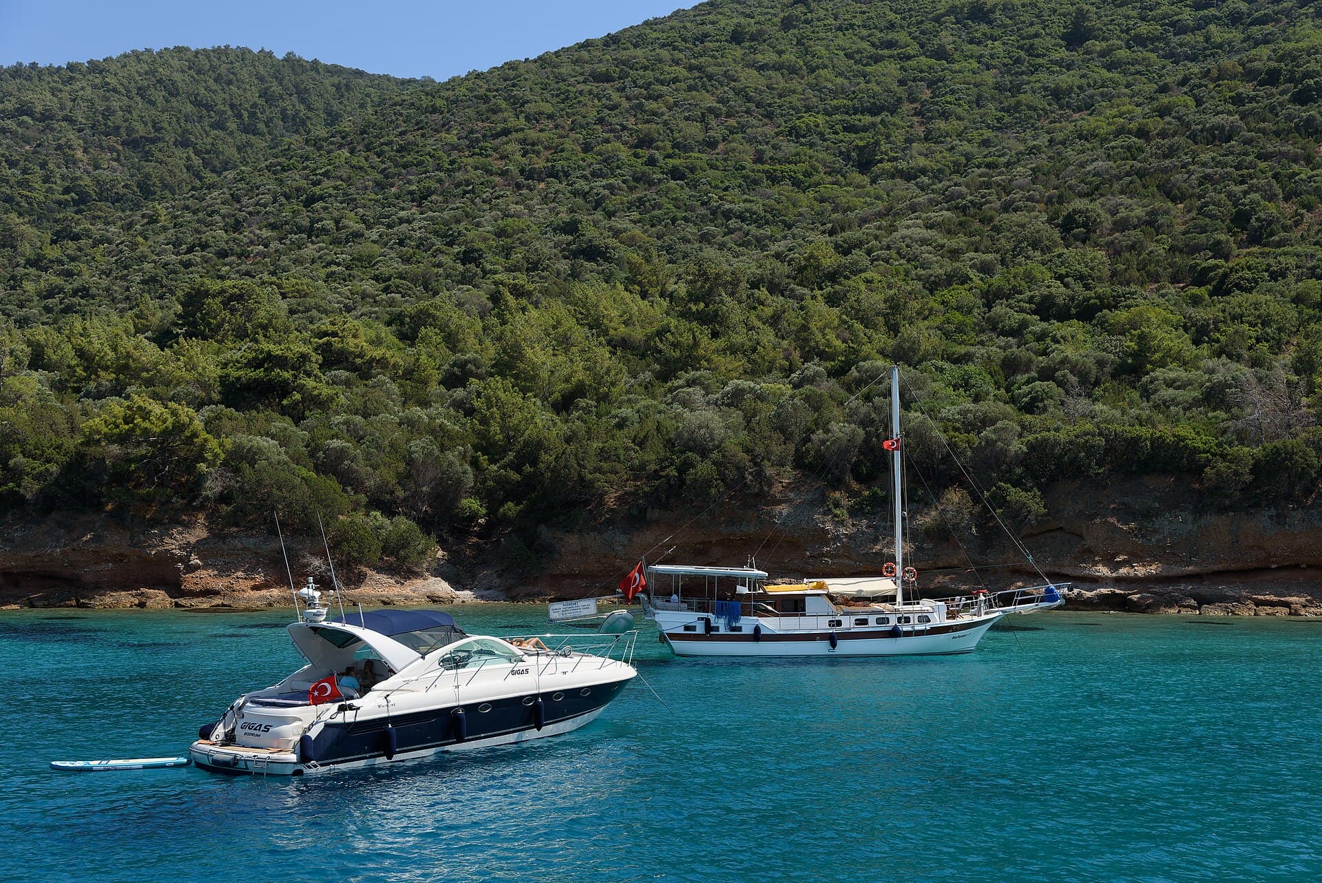 Boaters relaxing in clear turquoise water near Karaada island, Bodrum, Türkiye.
