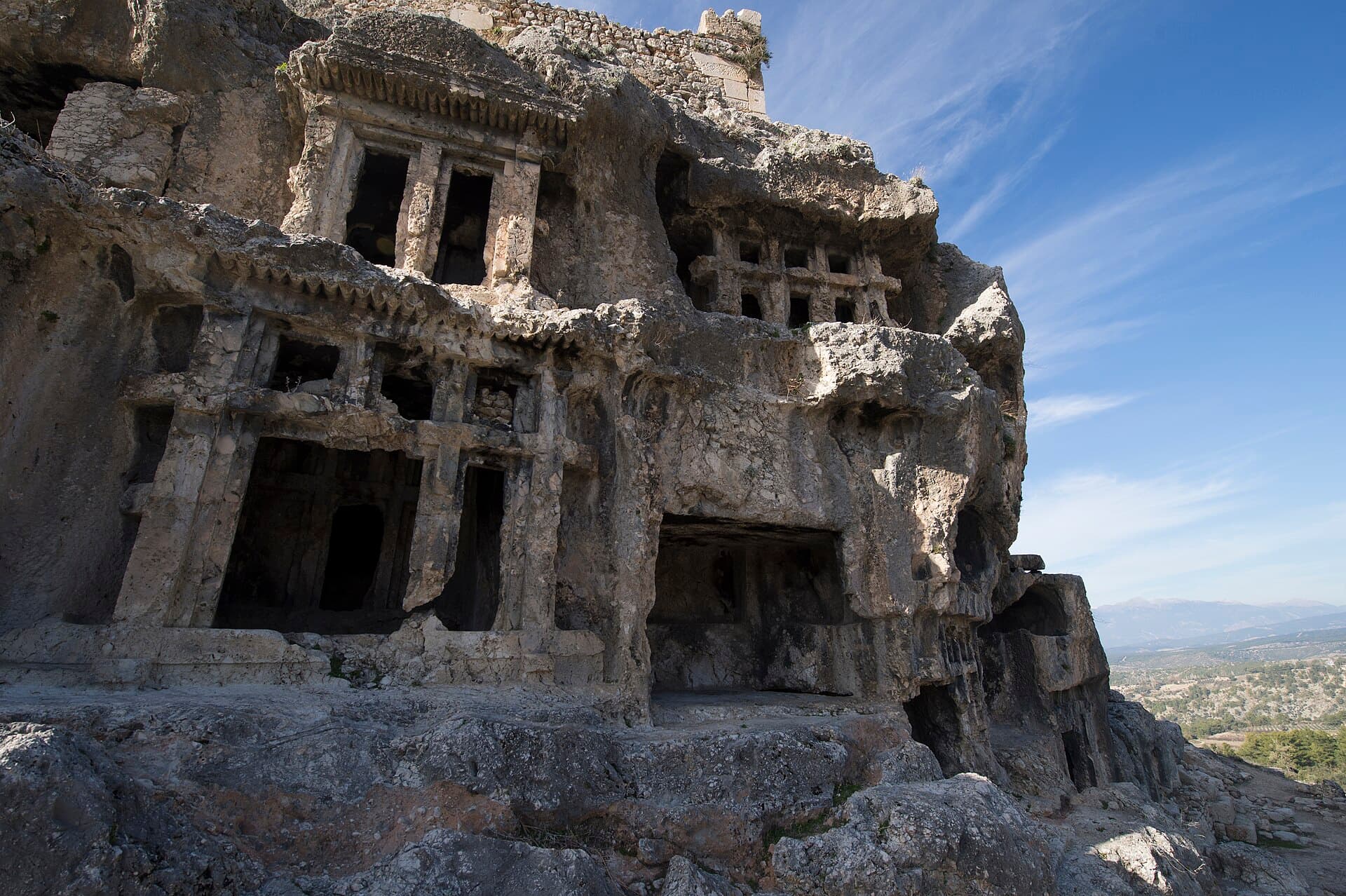 Rock-cut Lycian tombs carved into the cliff below Tlos's acropolis hill.