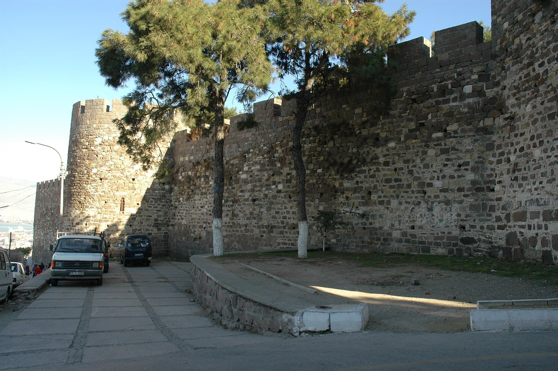 Weathered stone ramparts of Kadifekale fortress overlooking İzmir on a sunny day.