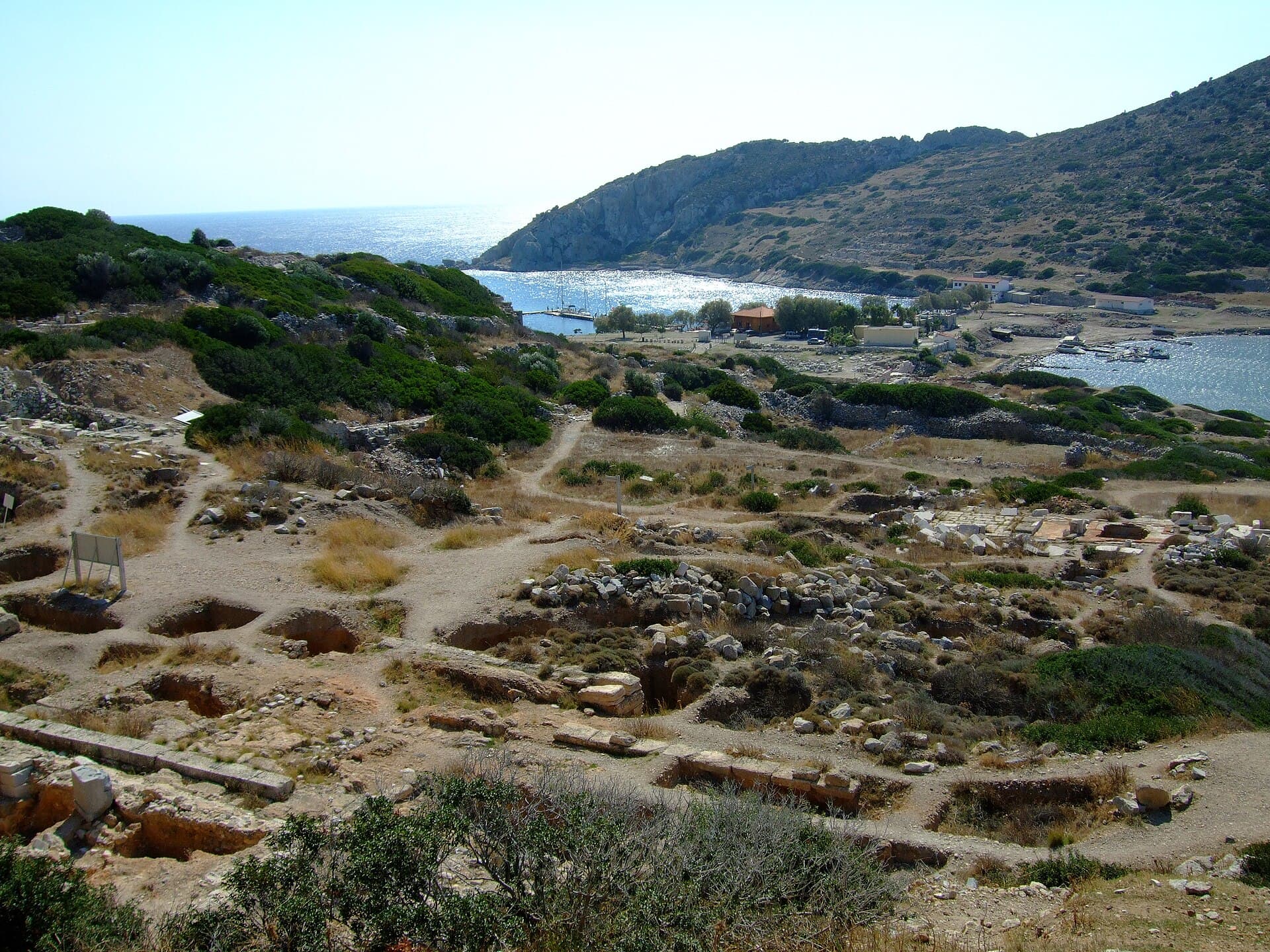 Excavated ruins overlook Knidos's sparkling harbour framed by rocky headlands.