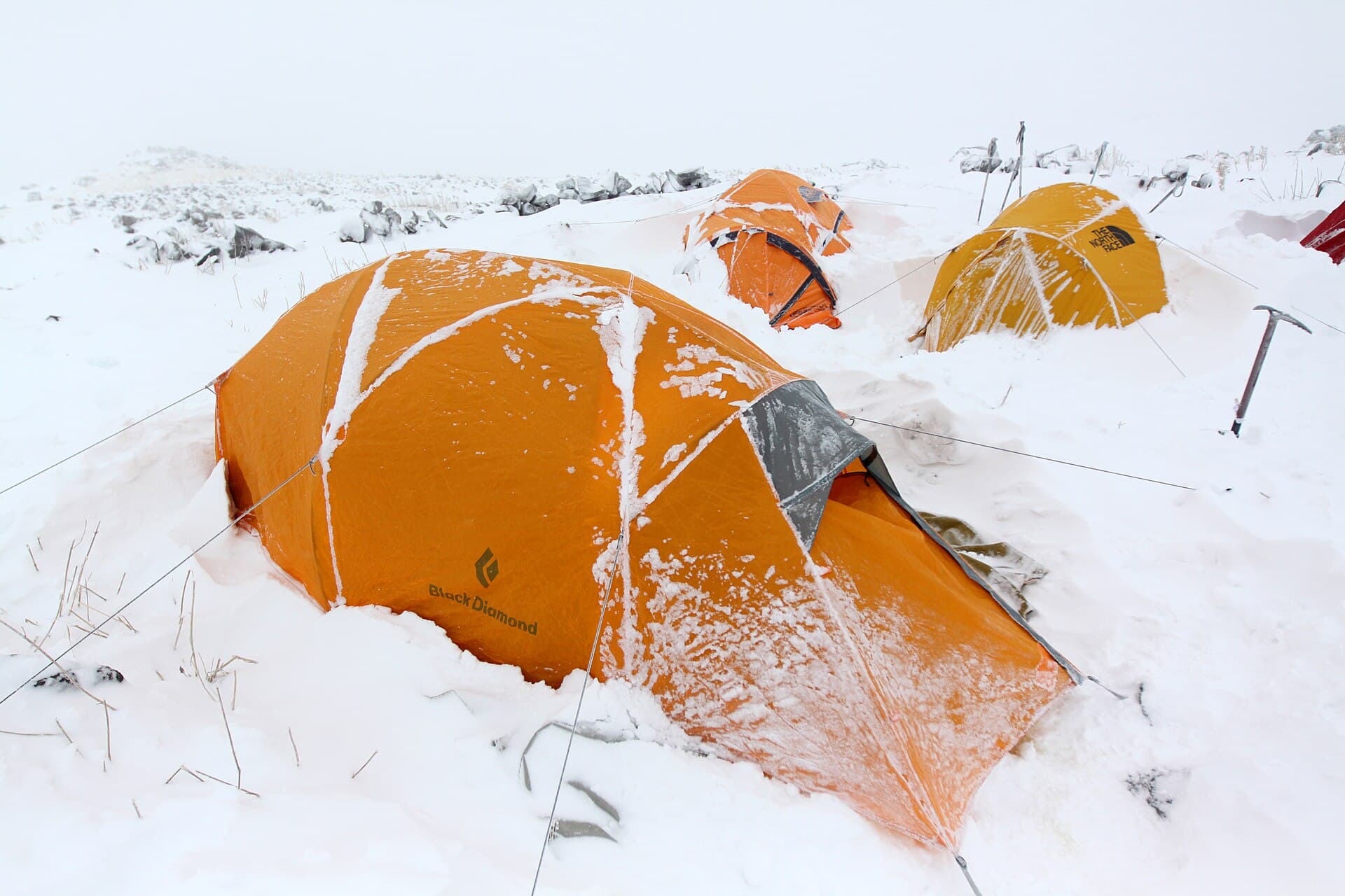 Snow-covered mountaineering tents at a high camp on Mount Ararat during a storm