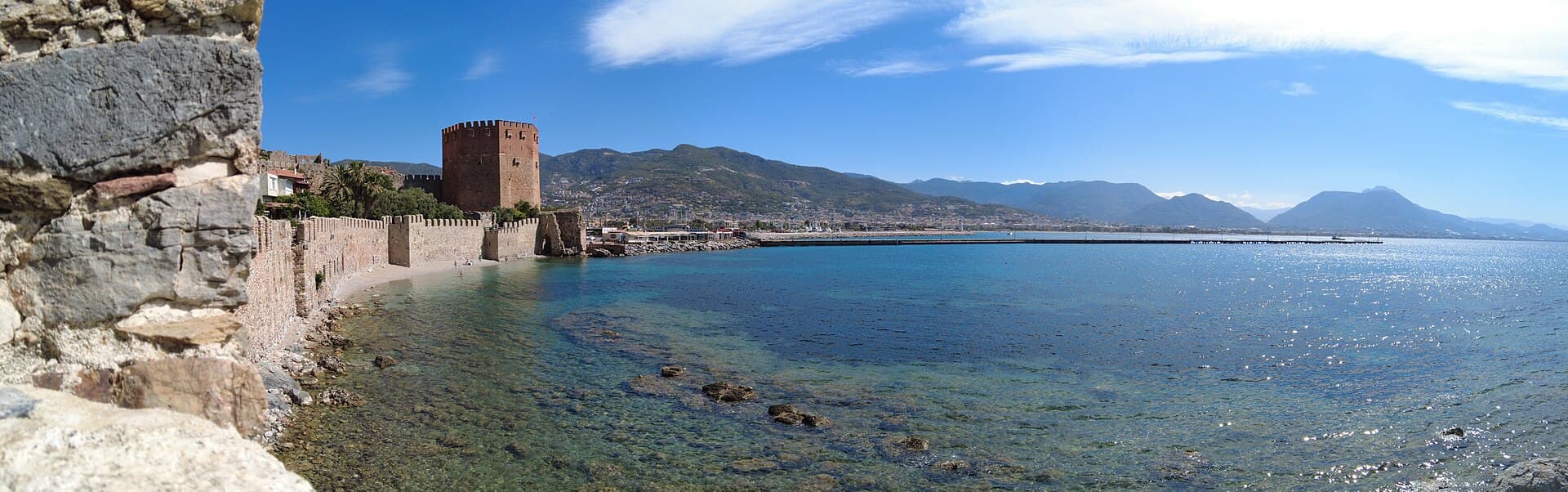Panoramic harbour view of the Red Tower at Alanya's harbour edge.
