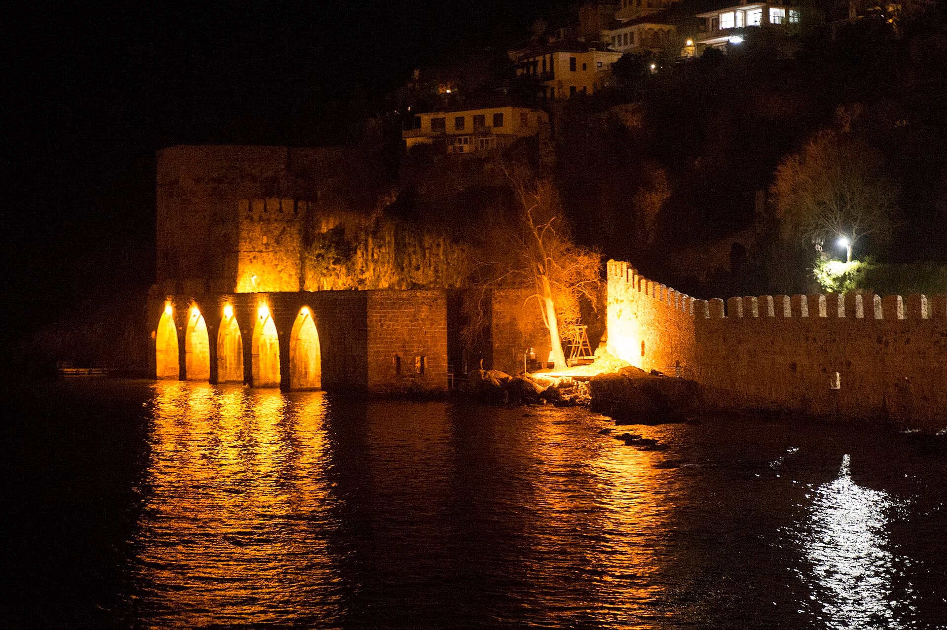 Exterior view of the Tersane shipyard's arched docks in Alanya at evening.