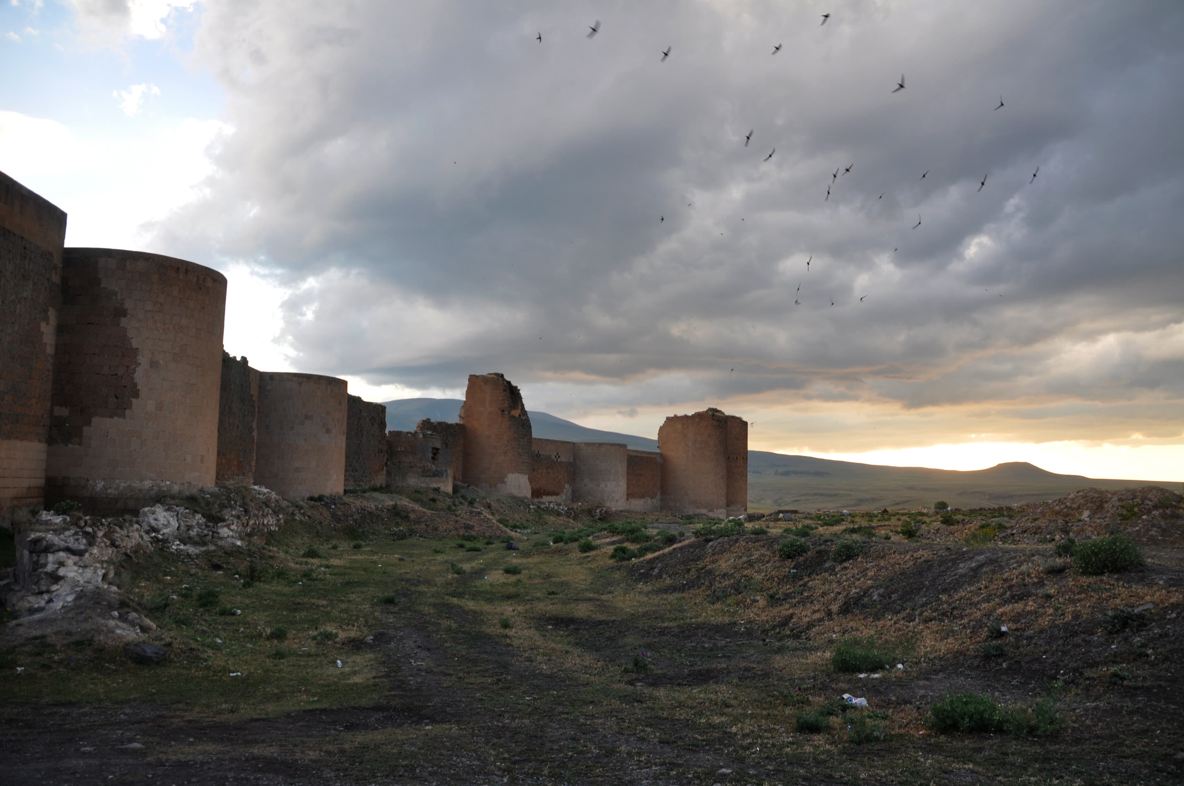 Ani's ruined medieval city walls with round defensive towers under a dramatic sky
