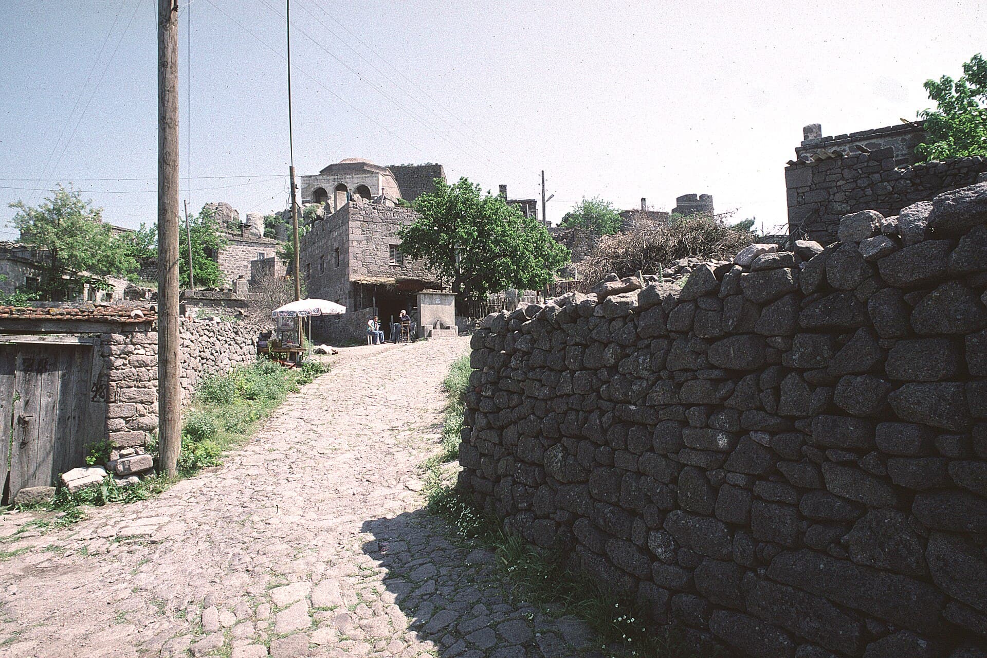 Narrow cobbled lane between stone houses in Behramkale village, Assos.