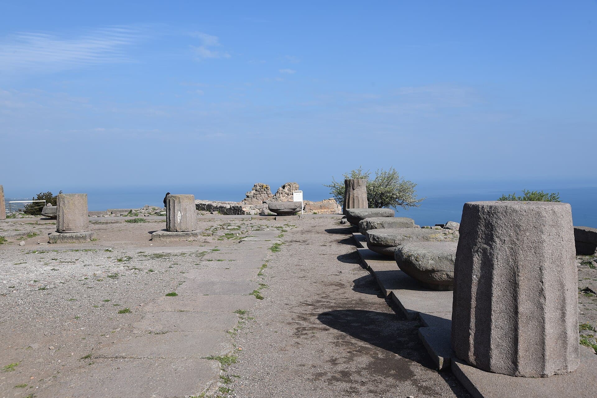 The Doric Temple of Athena at Assos overlooking the Aegean Sea in bright daylight.