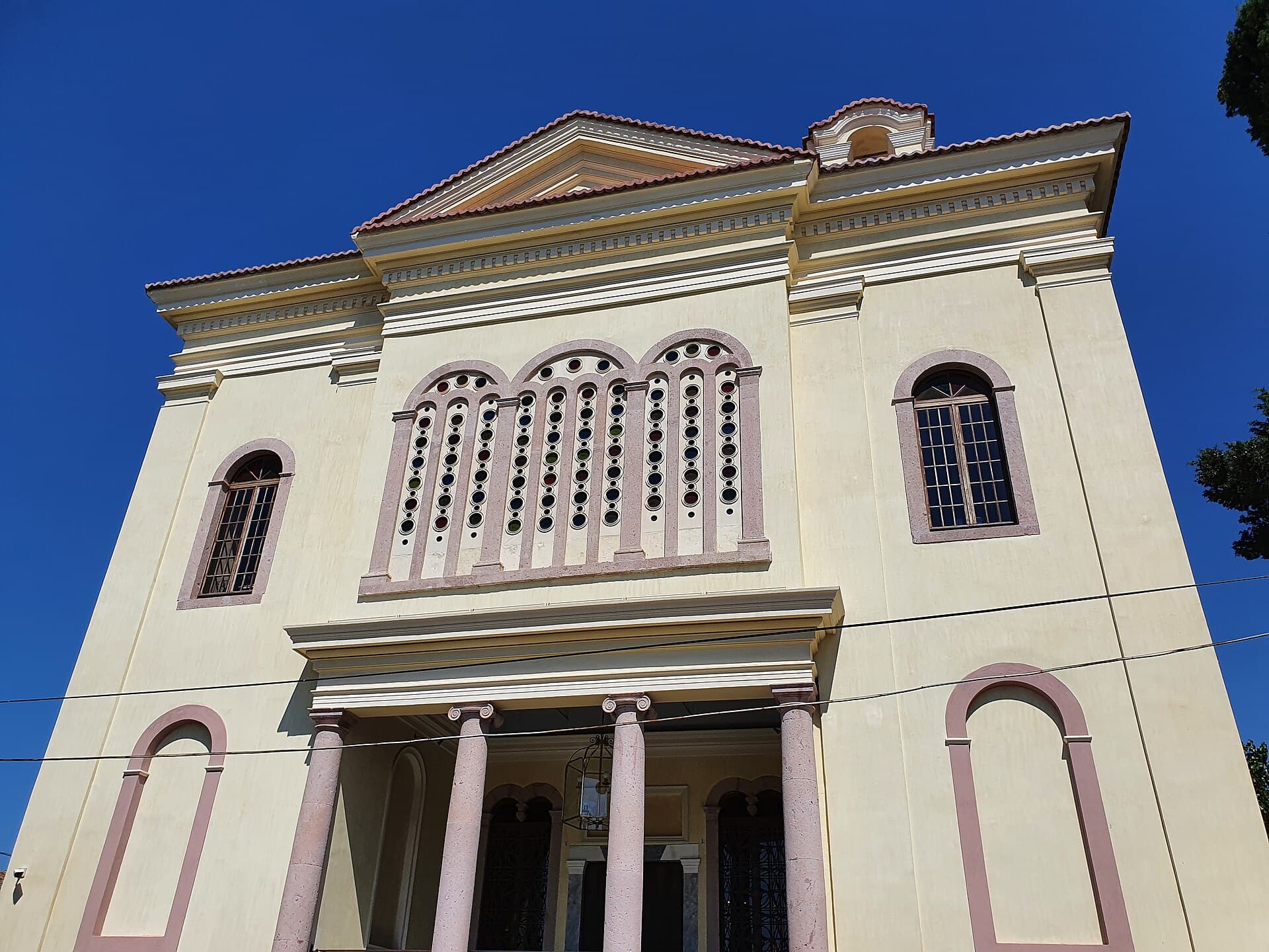 Exterior of the restored Taxiarchis Church (Cunda Rahmi M. Koç Museum) in daylight.
