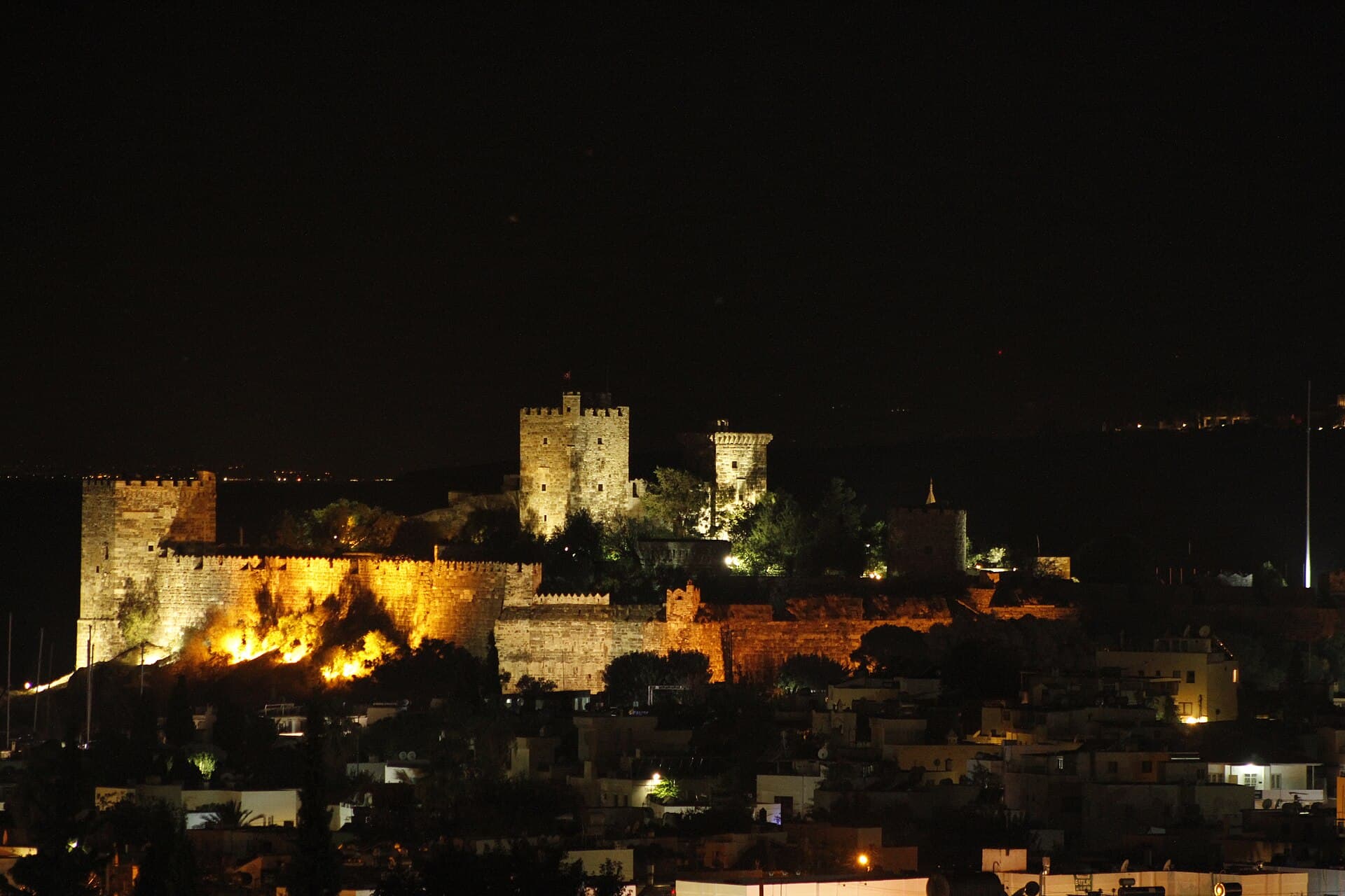 Bodrum Castle's Crusader towers illuminated against the night sky.