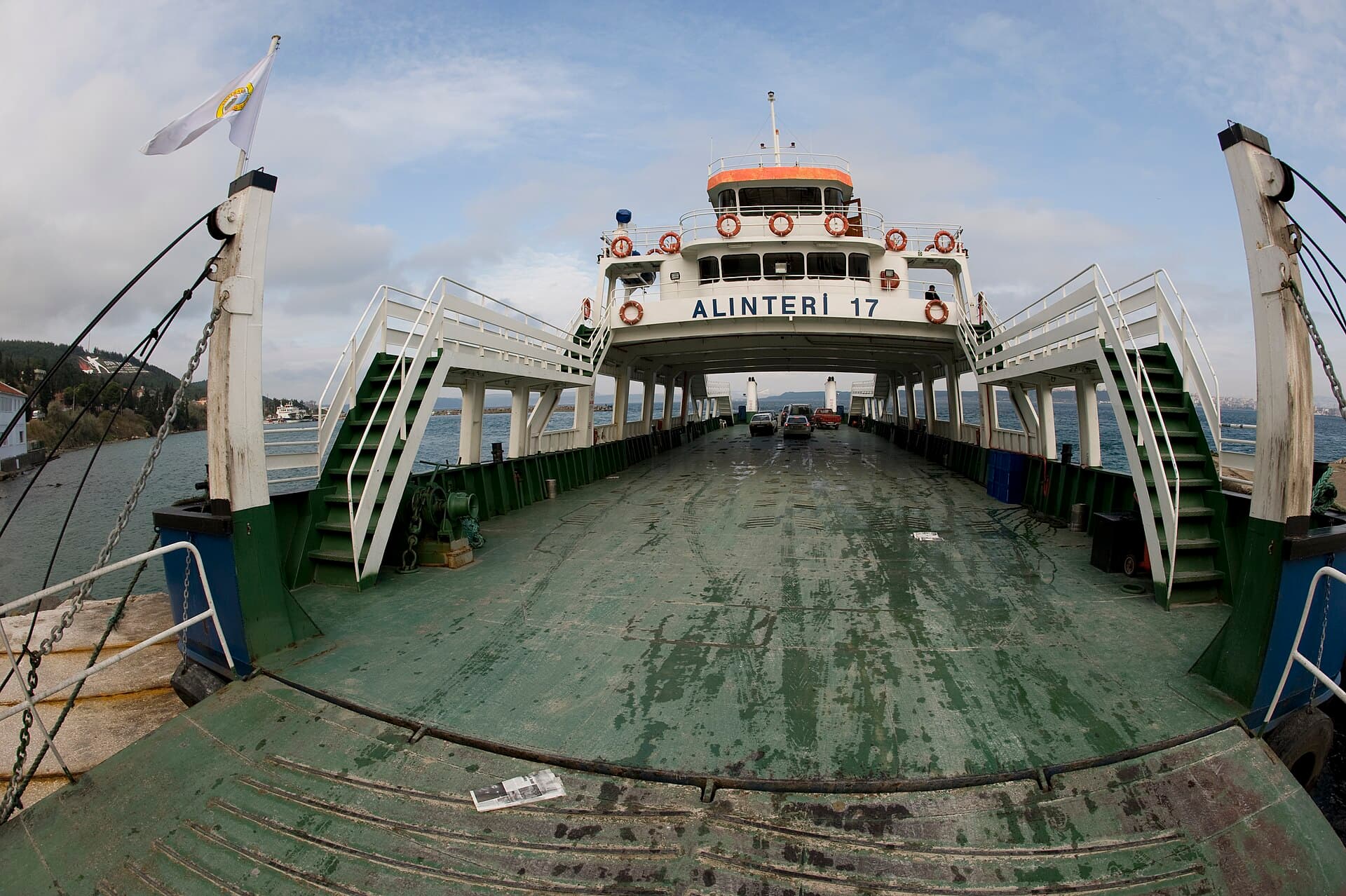 Car ferry crossing the Dardanelles Strait, vehicle deck and shoreline visible