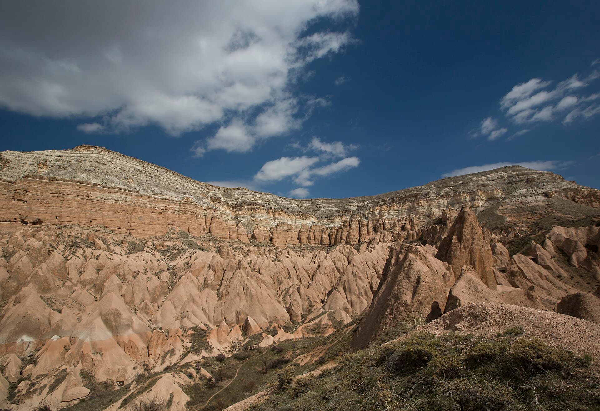 Panoramic view of the red and orange tuff rock formations of Red Valley (Kızılçukur) in Cappadocia
