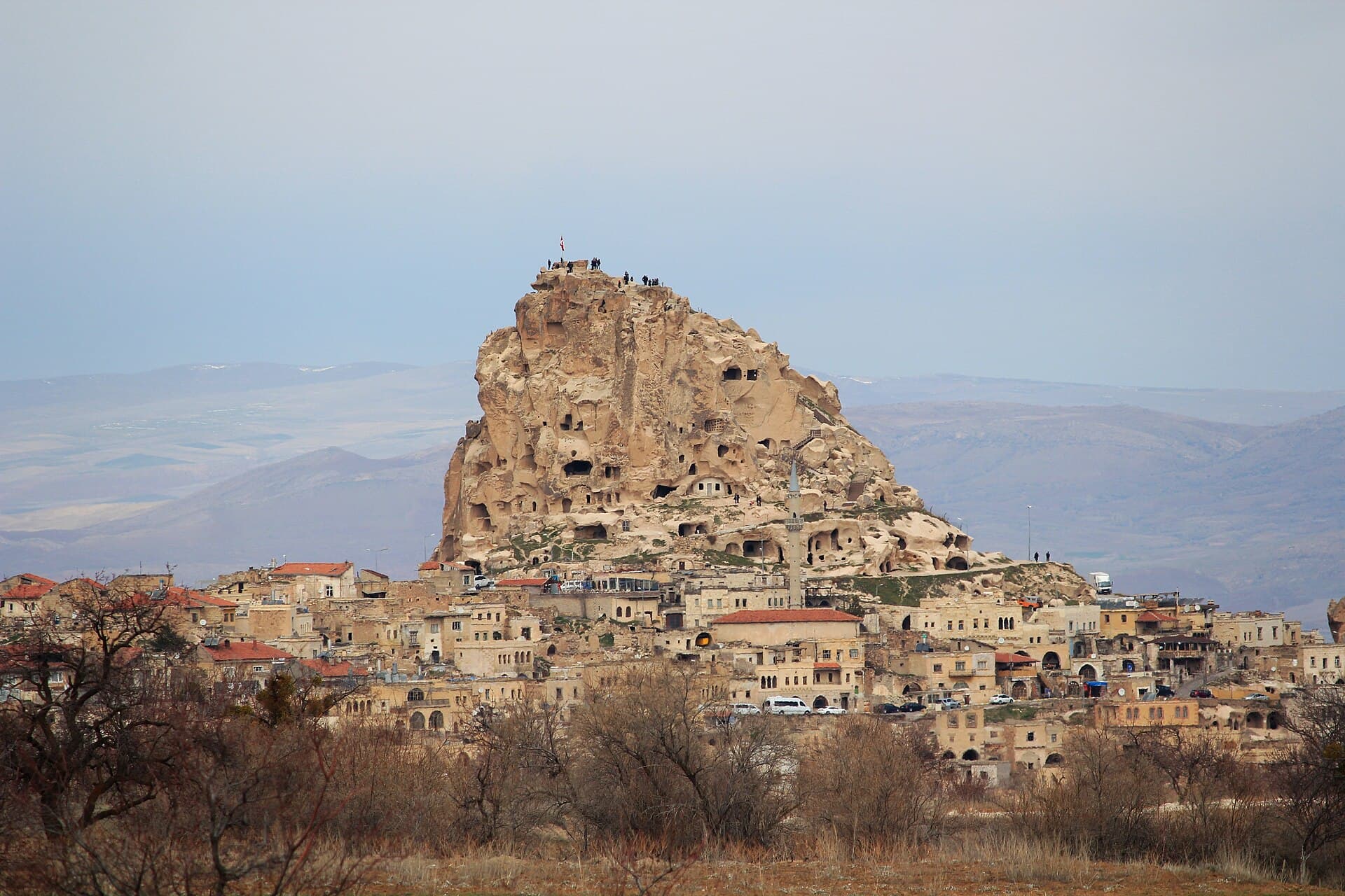 Uçhisar Castle's rock outcrop seen from a distance, its slopes honeycombed with carved rooms and windows