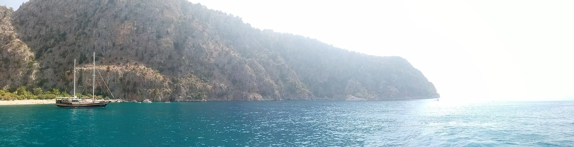 Panoramic coastal view of Butterfly Valley's cliffs and shoreline near Ölüdeniz, Turkey