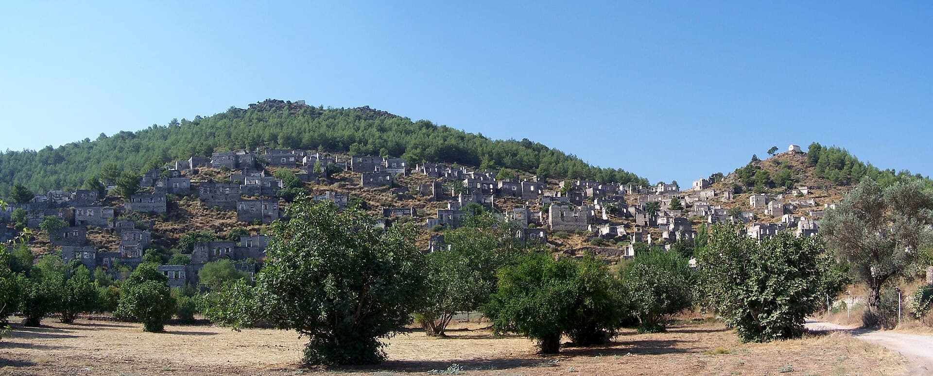 Panoramic hillside view of Kayaköy's hundreds of abandoned roofless stone houses.