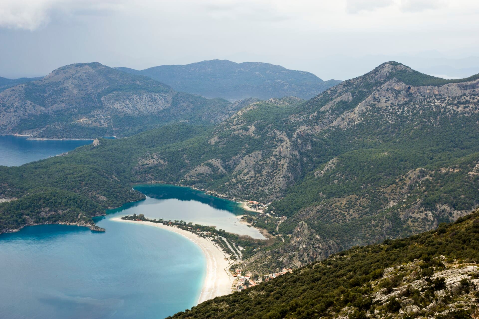 Aerial view of Ölüdeniz's turquoise lagoon enclosed by a narrow sandy spit.