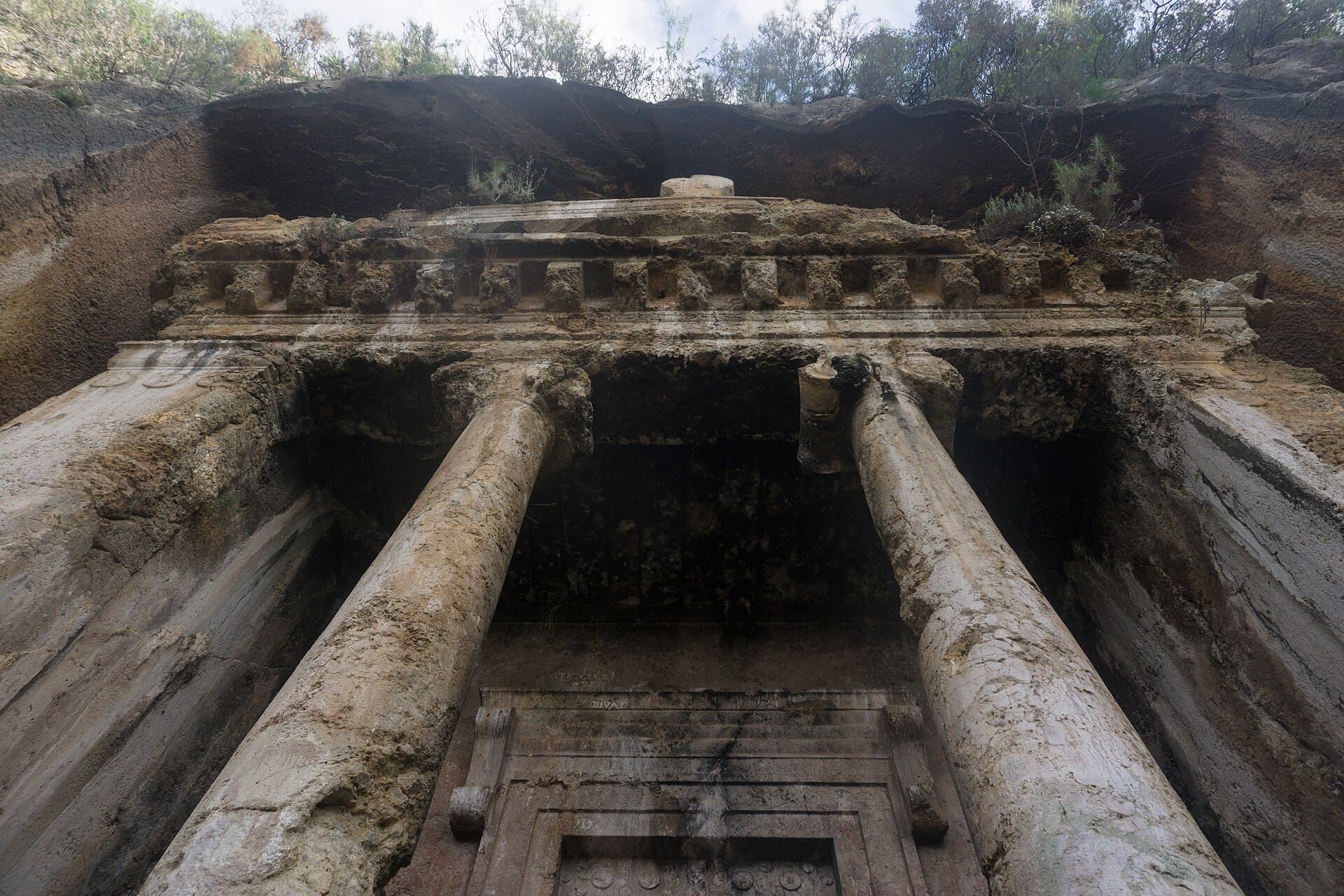 Dramatic upward angle of the Tomb of Amyntas's Ionic columns and pediment.