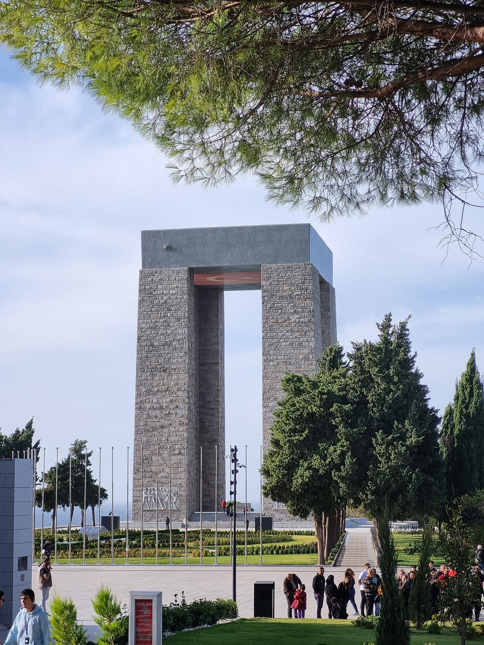 Distant view of the memorial tower in its park, framed by tree branches