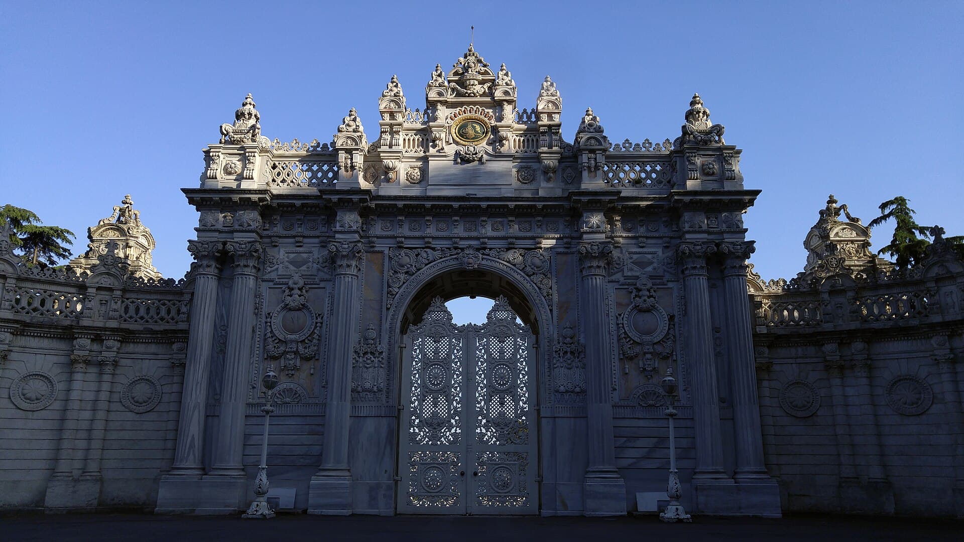 The ornate marble Sultan's Gate at Dolmabahçe Palace, topped with a gilded Ottoman imperial emblem