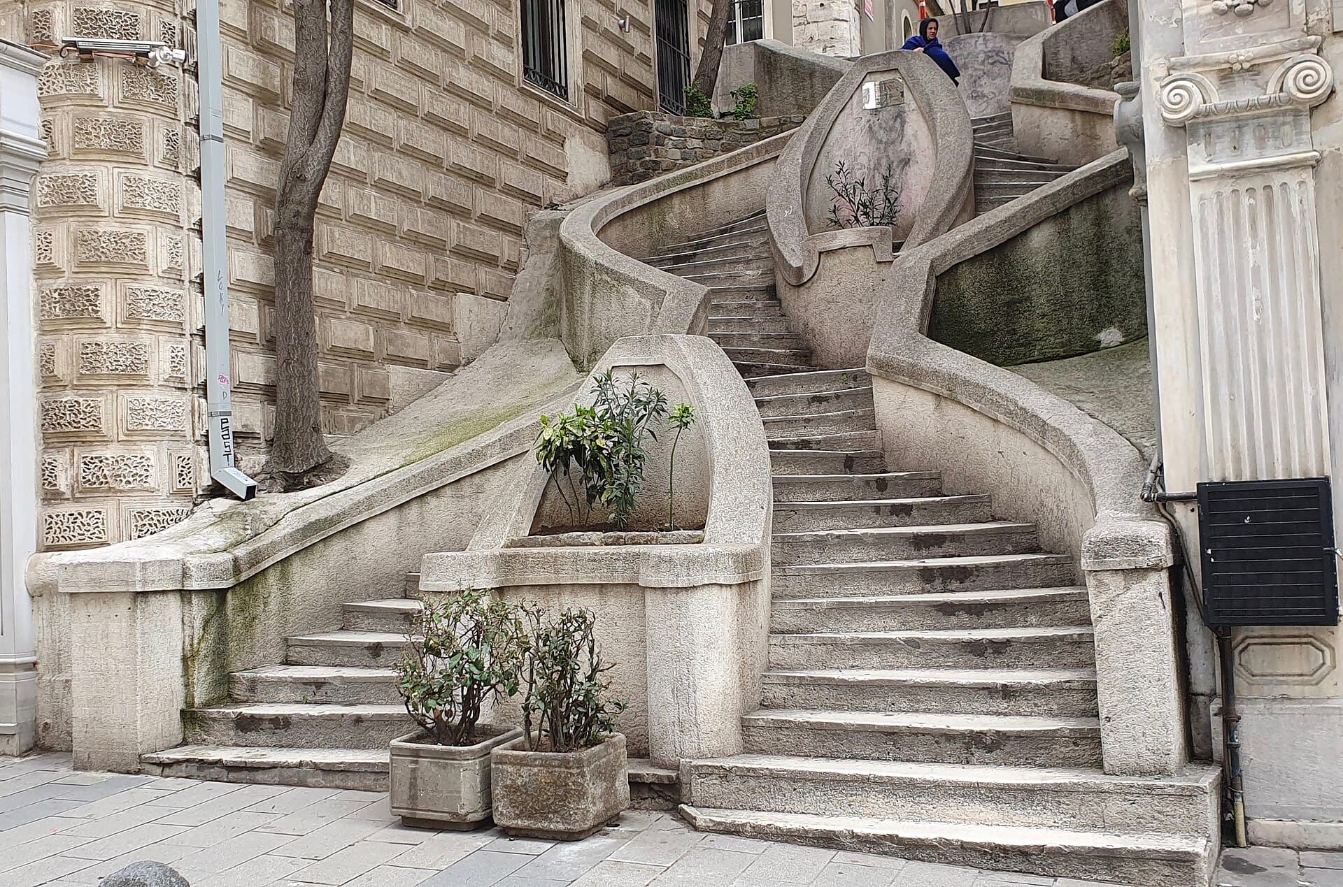 The curved stone staircase of the Kamondo Steps in Galata, framed by historic building façades near Bankalar Caddesi