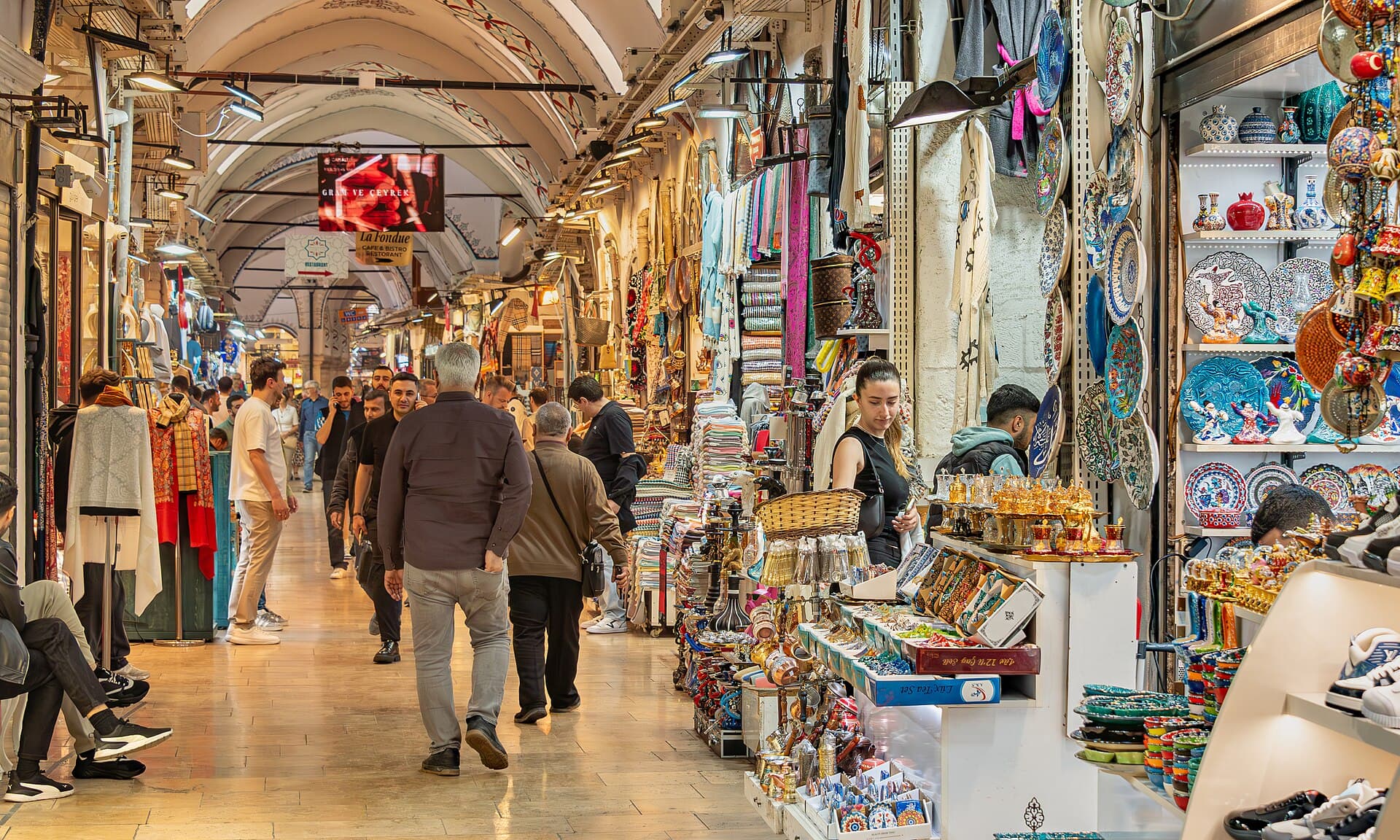 A covered lane in Istanbul's Grand Bazaar with a painted vaulted ceiling stretching overhead and shops lining both sides