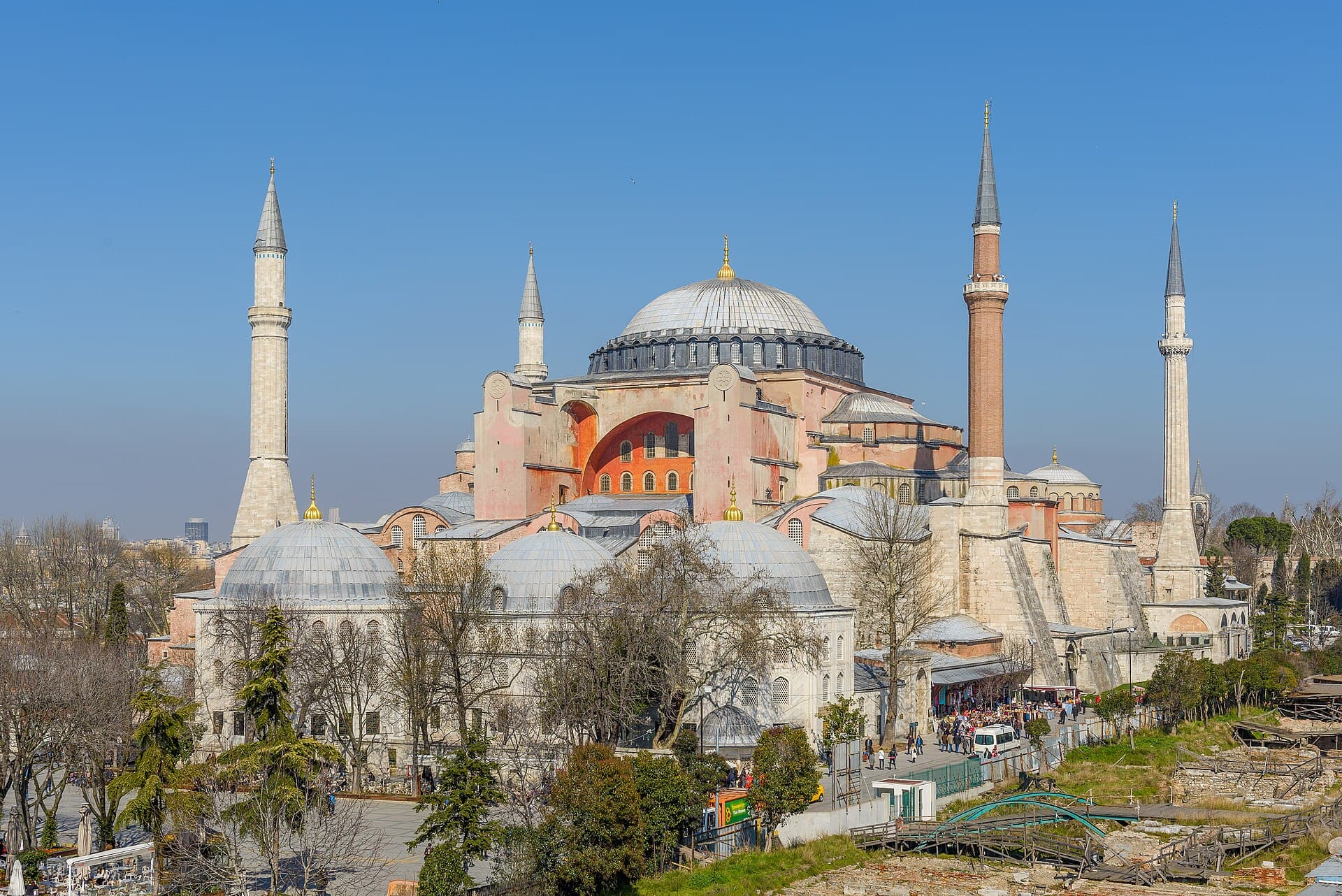 Exterior view of Hagia Sophia's domes and minarets rising above Sultanahmet under a clear blue sky