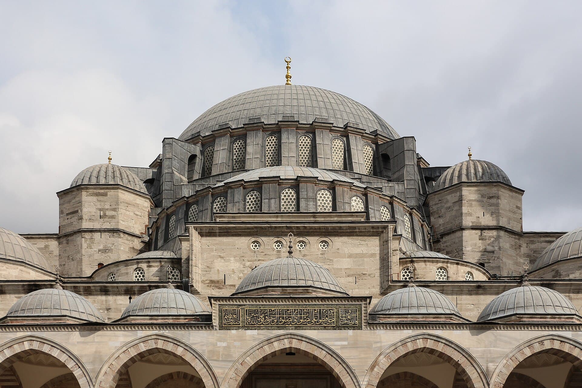 Cascading lead-clad domes and semi-domes of the Süleymaniye Mosque seen from its courtyard arcade