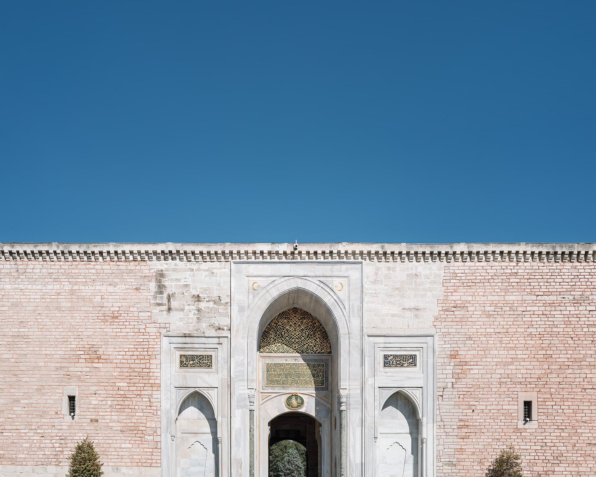 The Imperial Gate (Bab-ı Hümayun) of Topkapı Palace, its marble portal inscribed with Ottoman calligraphy against a clear sky