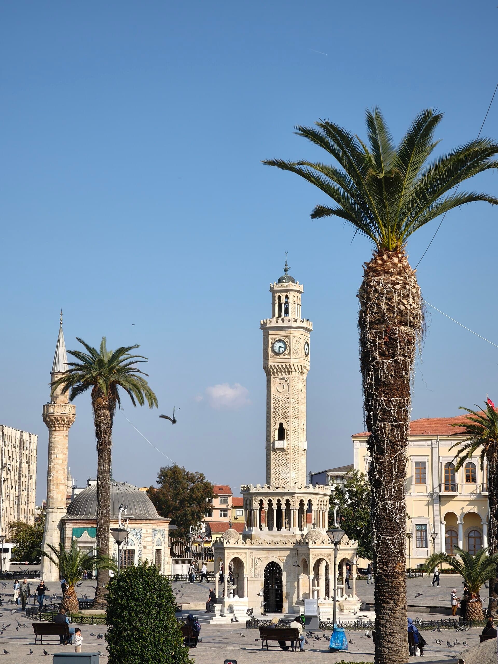 Konak Clock Tower with tiled Yalı Mosque and government building behind it.