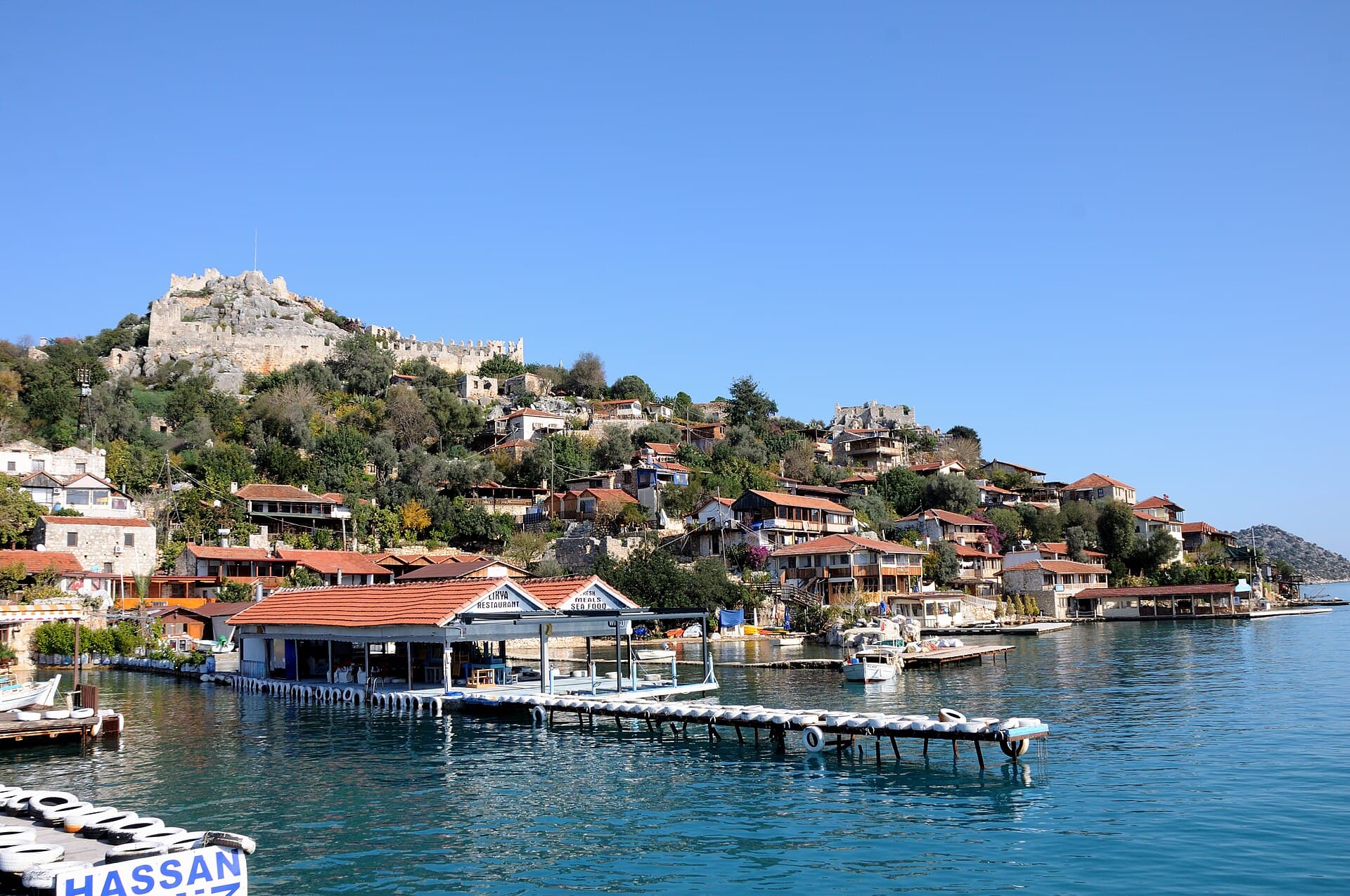 Kaleköy's harbourside village with Byzantine Simena Castle on the hill above.