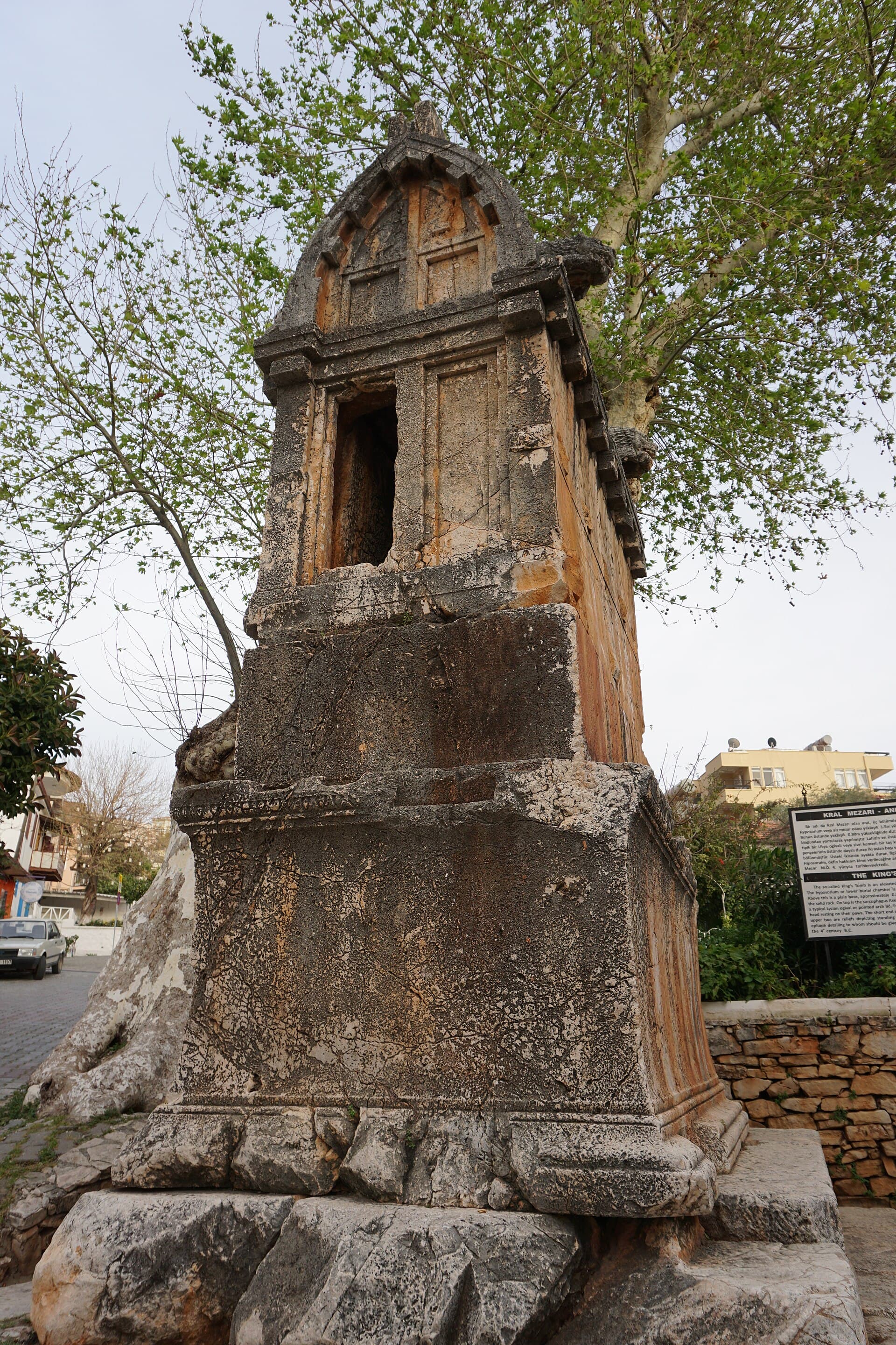 Ancient Lycian lion sarcophagus standing among modern houses in Kaş, Türkiye.