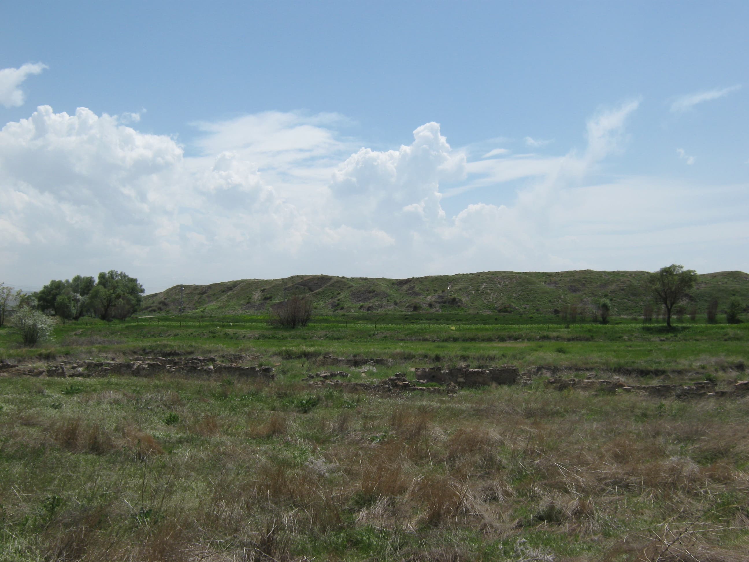 The Kültepe mound seen from the lower town (karum), against open Anatolian plateau farmland.