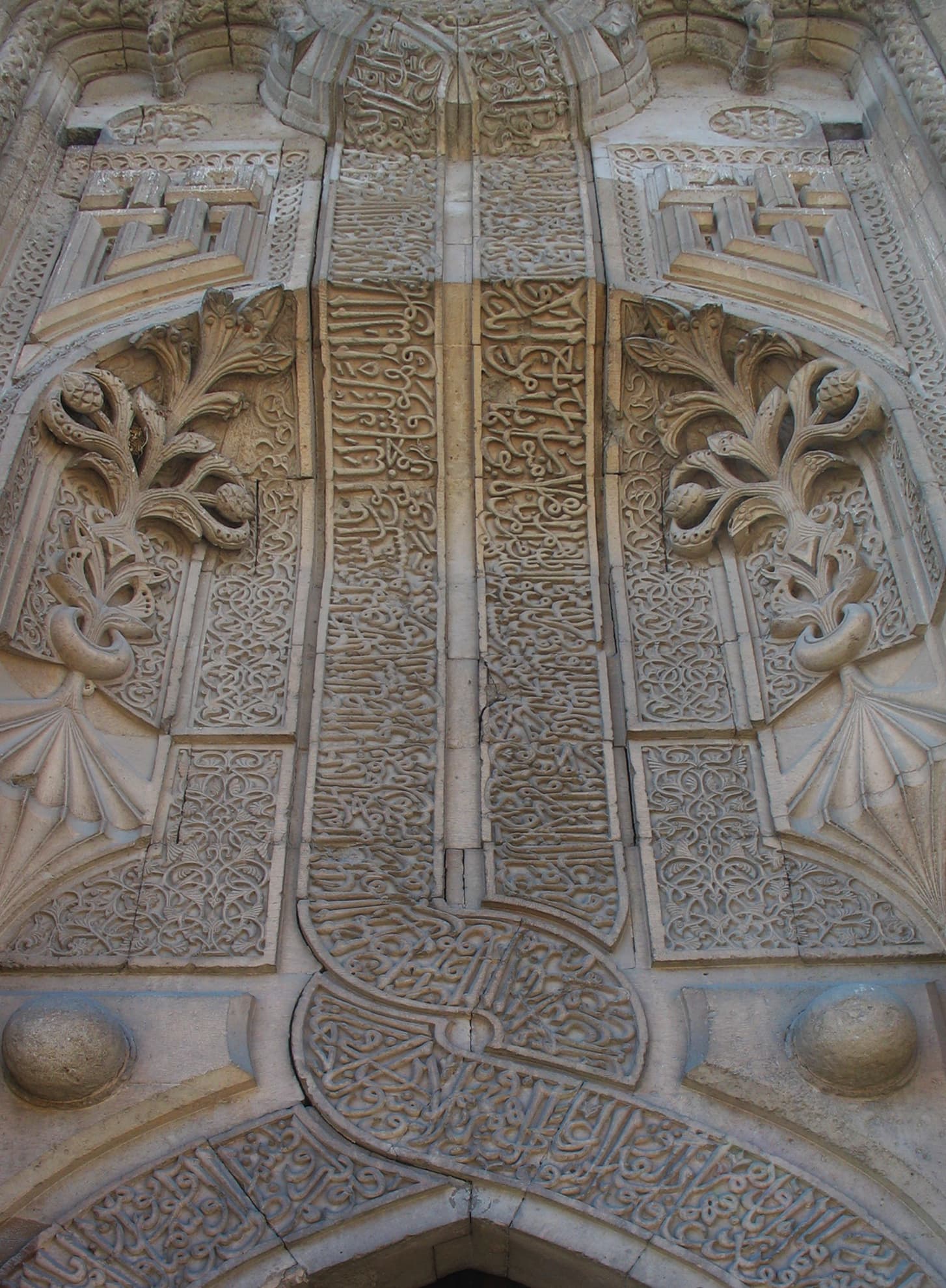 Densely carved stone portal with Arabic calligraphy at İnce Minareli Medrese, Konya.