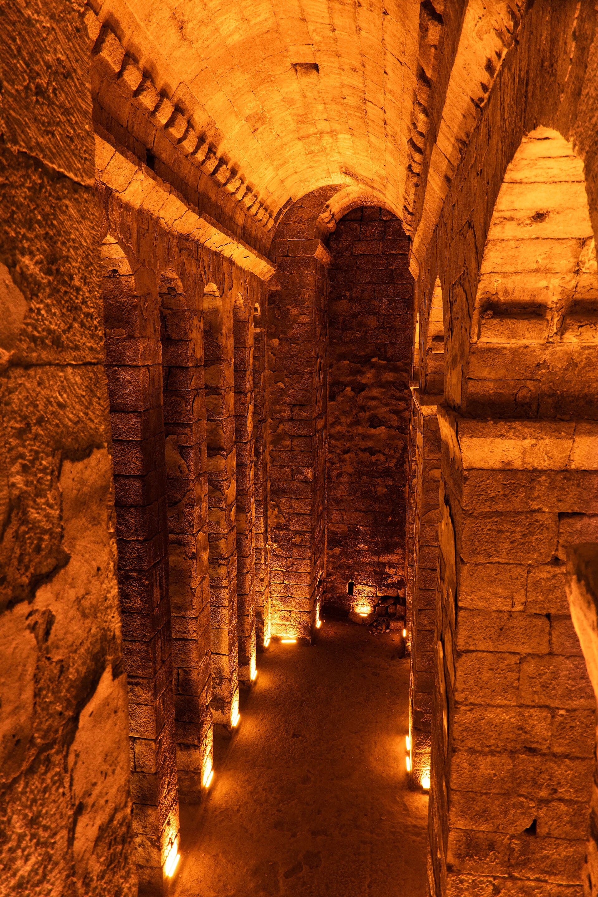 Illuminated vaulted stone gallery inside Dara's rock-cut underground cistern.