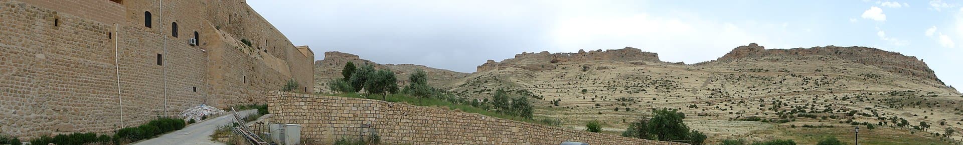 Deyrulzafaran Monastery's stone walls stretching along a hillside near Mardin.