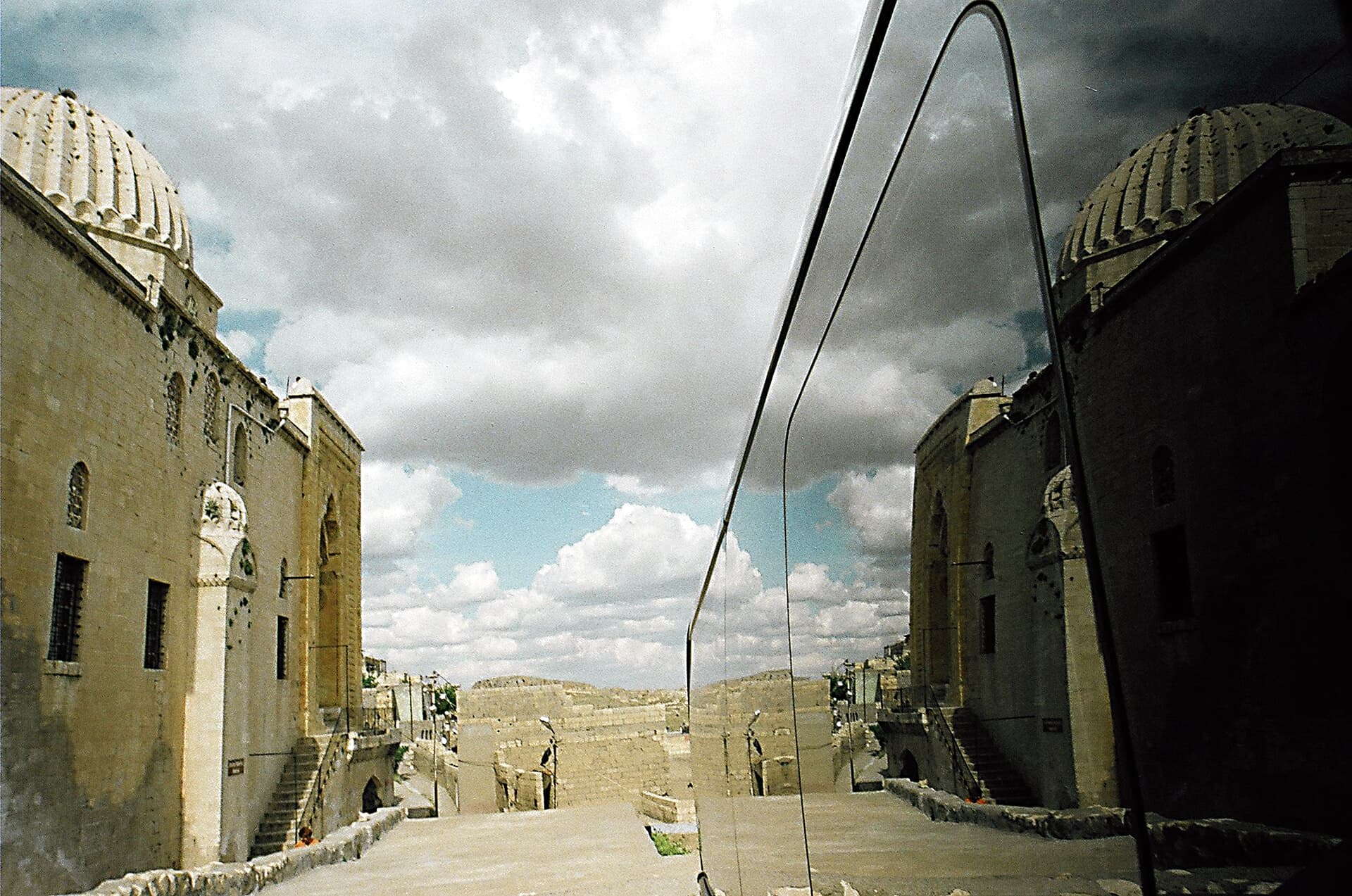 Symmetric domed buildings and stone terrace at Kasımiye Medresesi complex in Mardin.