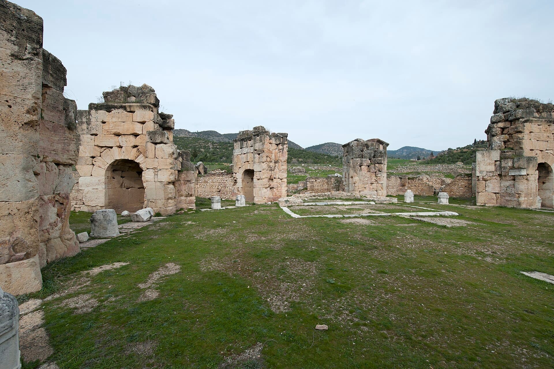 Ruined arched chambers of the octagonal Martyrium of St Philip surround a grassy central court with traces of marble flooring and column plinths at Hierapolis.