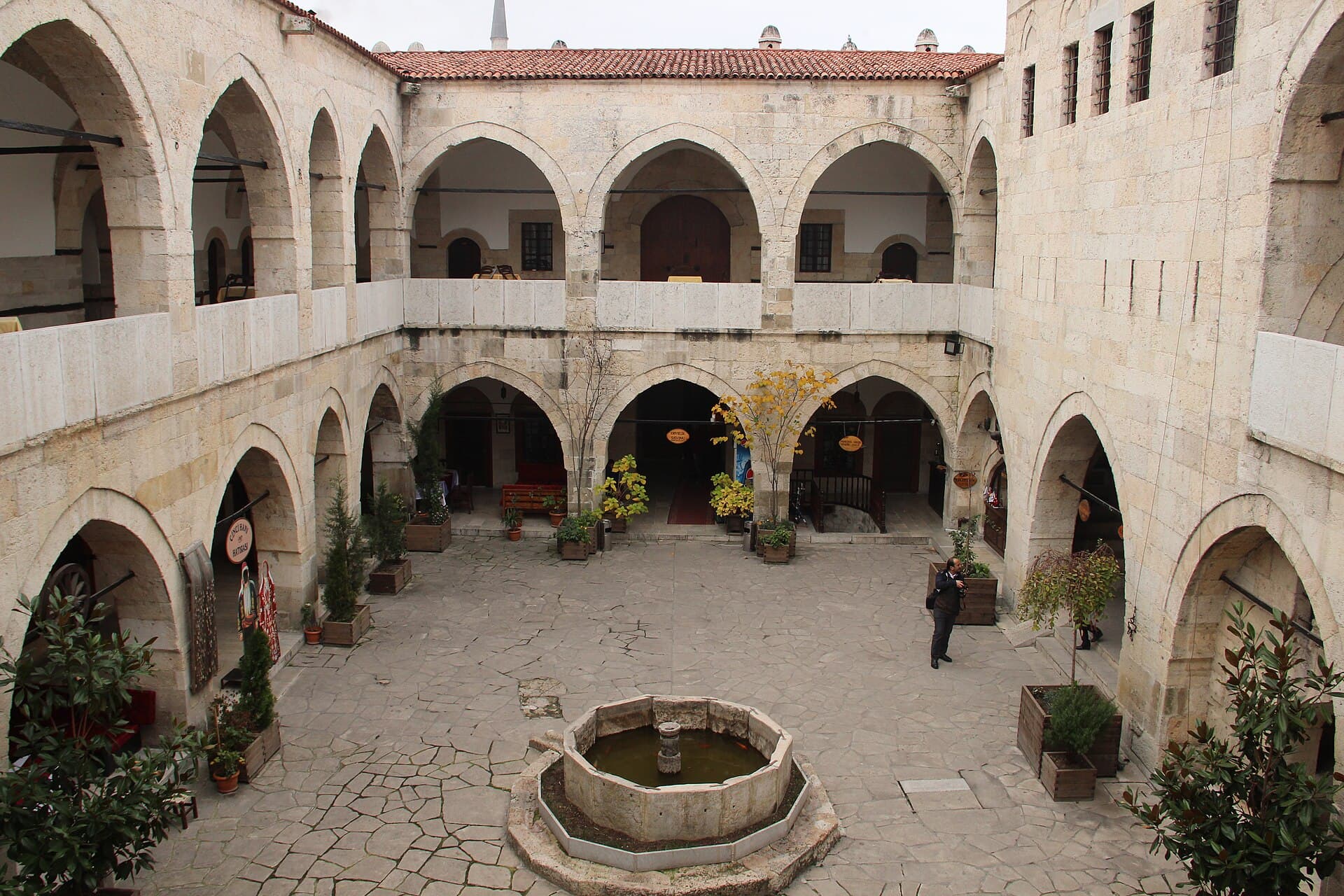Two-storey stone-arched courtyard of Cinci Han caravanserai with a central well.