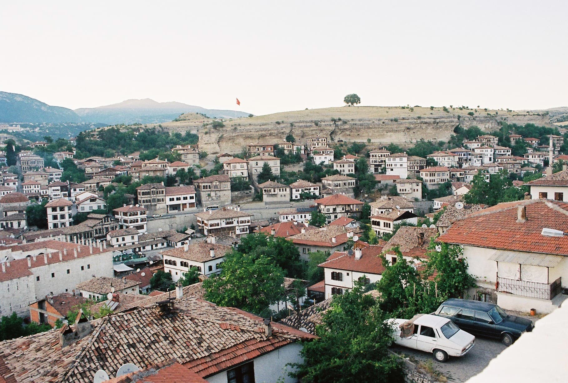 Elevated view of Safranbolu's Ottoman old town, red-tiled roofs filling a wooded valley.
