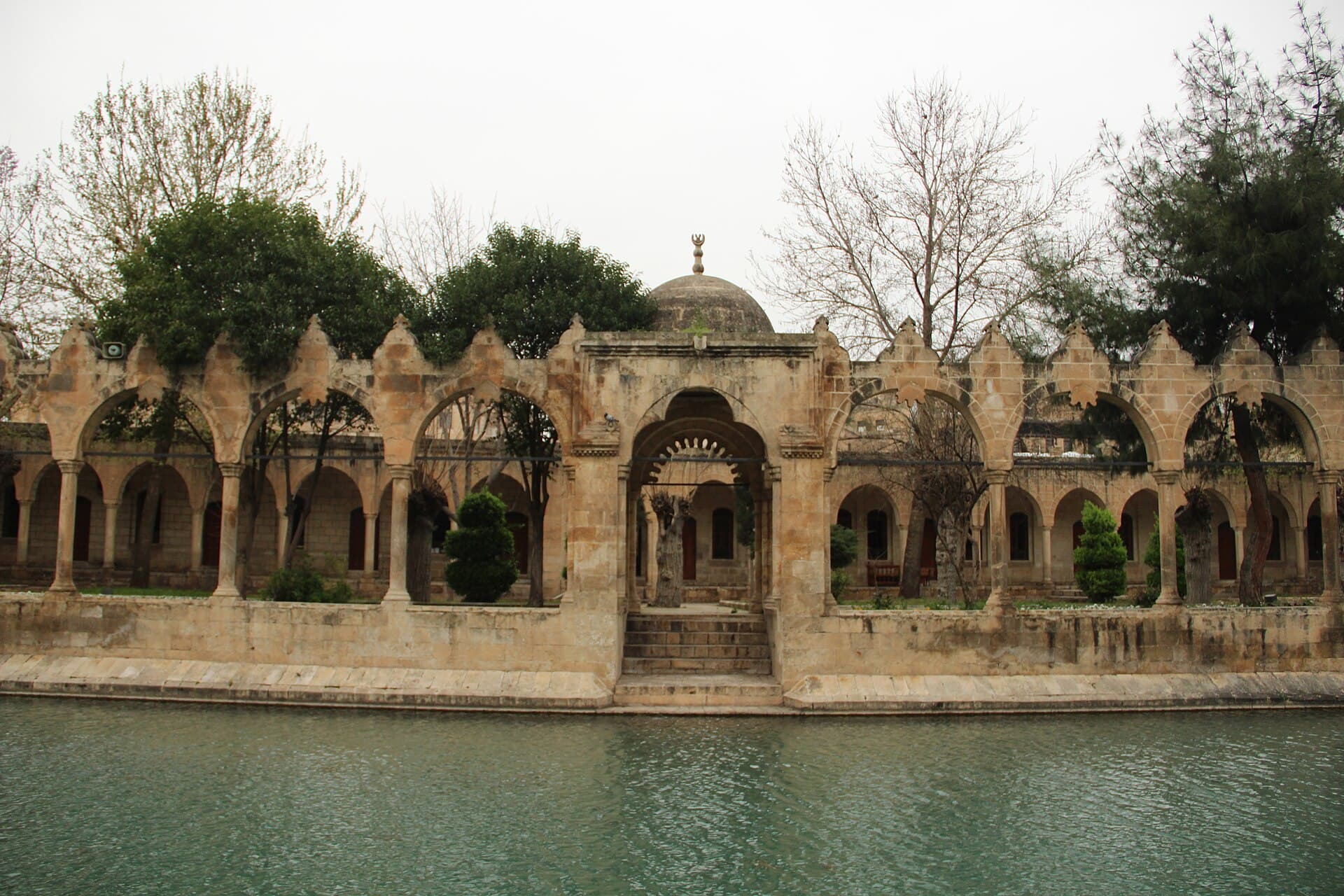 Sacred carp pool at Balıklıgöl surrounded by arcaded stone walkways, Şanlıurfa.