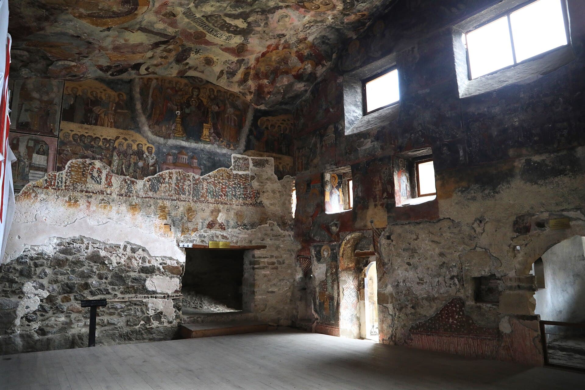 Painted saints and rock-cut windows inside Sümela's frescoed rock church chapel