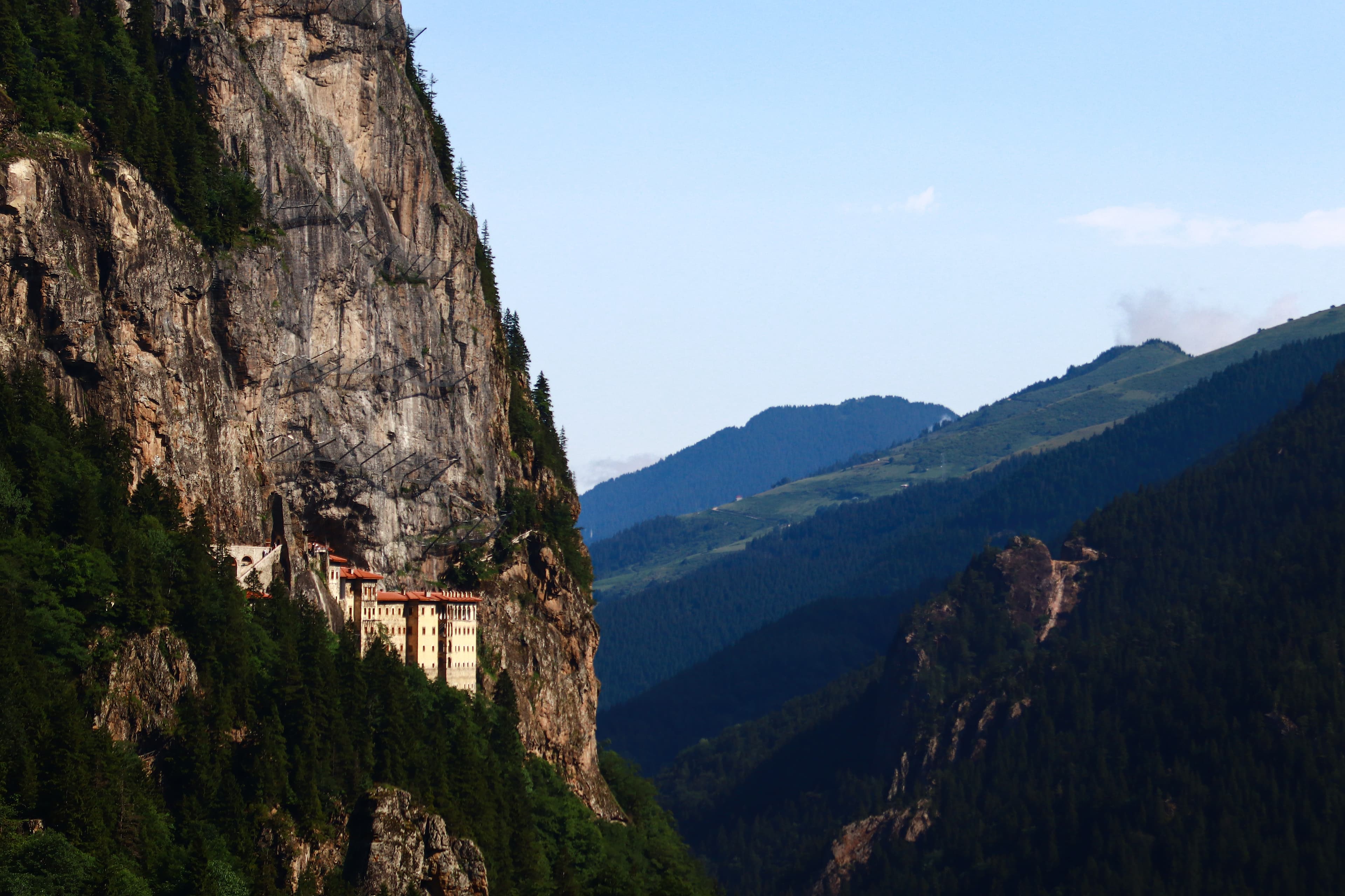 Wide view across Altındere gorge showing Sümela Monastery built into a sheer cliff face